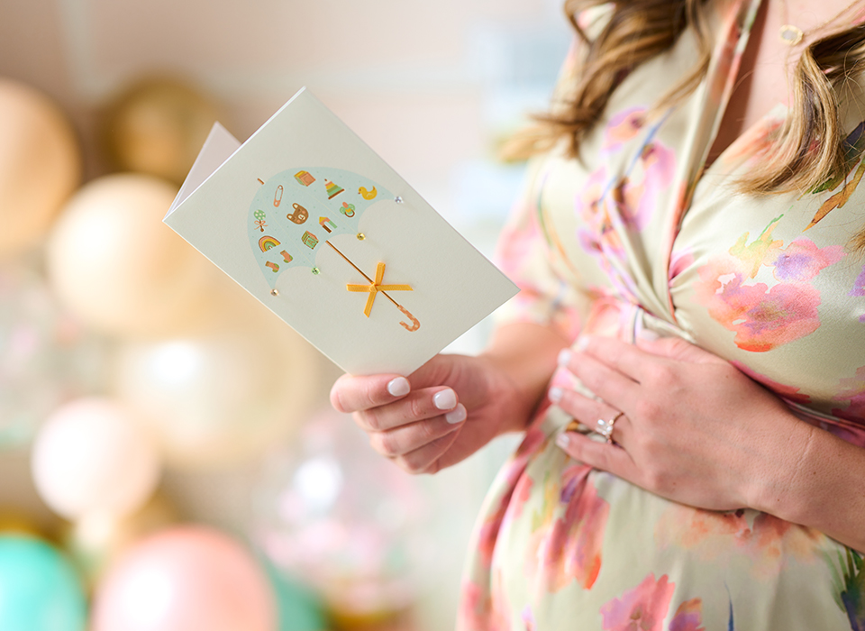 Expecting mother reading a baby shower card